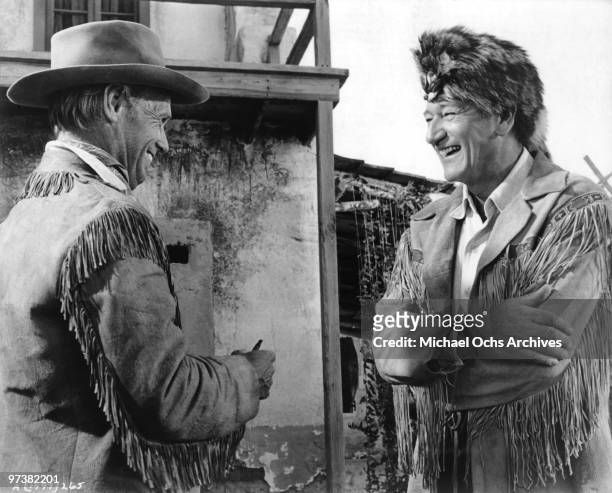 John Wayne chats with Richard Widmark on the set of his movie 'The Alamo' in 1960 at the Alamo Village he had built for the film in Brackettville,...