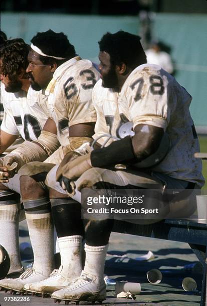 Offensive tackle Art Shell, guard Gene Upshaw of the Oakland Raiders watches the action from the bench circa 1970's during an NFL football game....