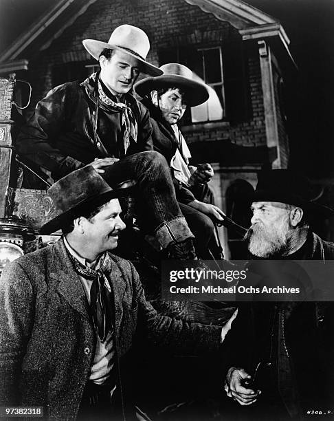 Seated John Wayne and Andy Divine, bottom left is George Bancroft on the set of the movie 'Stagecoach' in 1939.