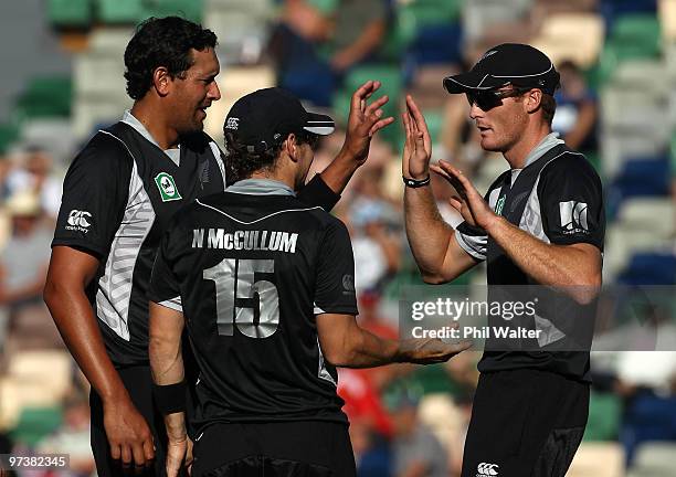 Daryl Tuffey of New Zealand celebrates his wicket of Nathan Hauritz of Australia with Brendon McCullum and Martin Guptill during the First One Day...