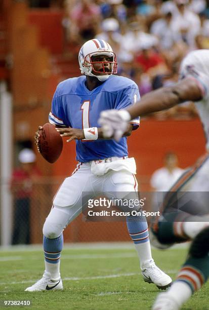 S: Quarterback Warren Moon of the Houston Oilers drops back to pass against the Miami Dolphins during a mid circa 1980's NFL football game at the...