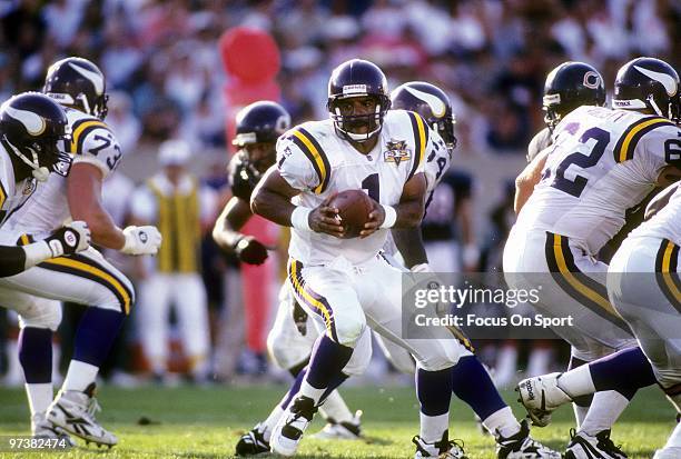 Quarterback Warren Moon of the Minnesota Vikings turns to hand the ball off to a running back against the Chicago Bears during an NFL football game...