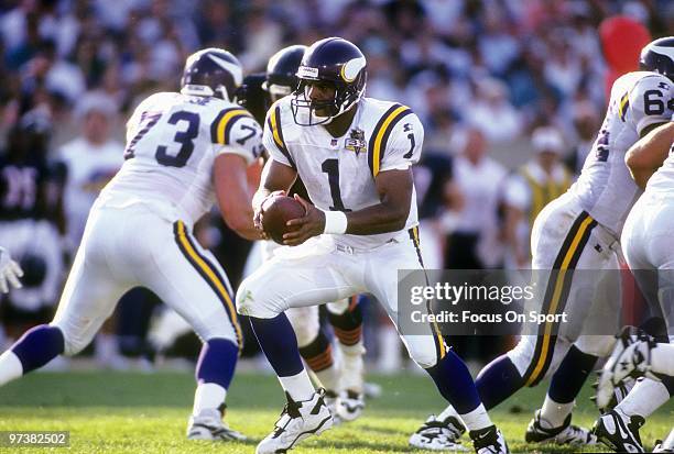 Quarterback Warren Moon of the Minnesota Vikings turns to hand the ball off to a running back against the Chicago Bears during an NFL football game...