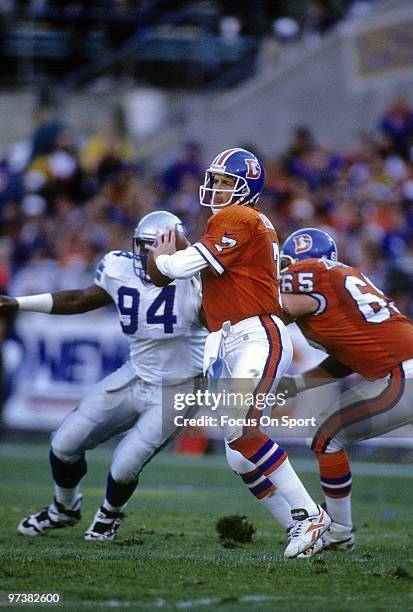 S: Quarterback John Elway of the Denver Broncos drops back to pass against the Seattle Seahawks circa 1980's during an NFL football game at Mile High...