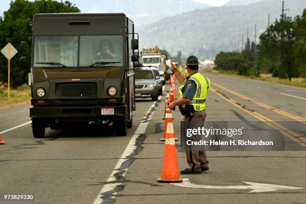 Driver gives a thumbs up to Colorado State Patrol officer Jason Bandy as he allows him to go through the road closure along Highway 550 on June 13,...