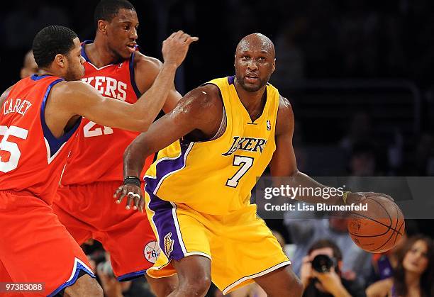 Lamar Odom of the Los Angeles Lakers drives to the basket against Rodney Carney and Thaddeus Young of the Philadelphia 76ers at Staples Center on...