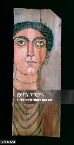 Mummy portrait, 90-110 AD. Fragments of a wooden mummy portait of woman with close curly hair wearing a gold pendant. Dimension: height: 308 cmwidth:...