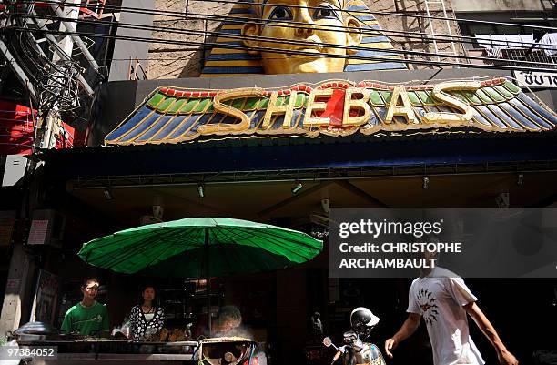 Man walks past a food stall at Soi Cowboy, one of Bangkok's red-light districts on March 3, 2010. Thailand's inflation rose for the fifth straight...