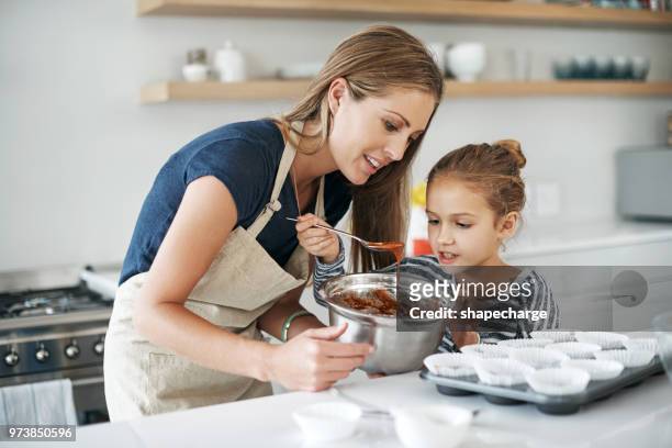 we both so proud of the yummy batter we made - mother daughter baking stock pictures, royalty-free photos & images