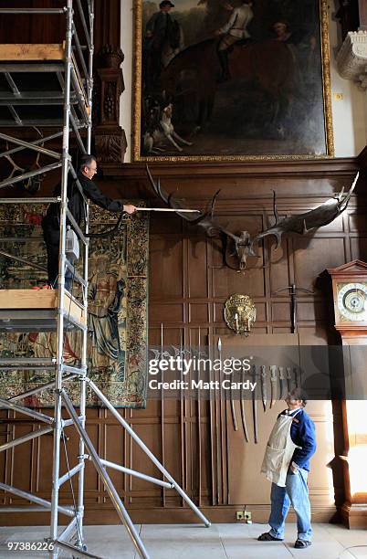 Longleat House conservator Ken Windess watches as house steward Steve Blyth cleans the 9ft wide prehistoric Giant Fallow Deer antlers that are...