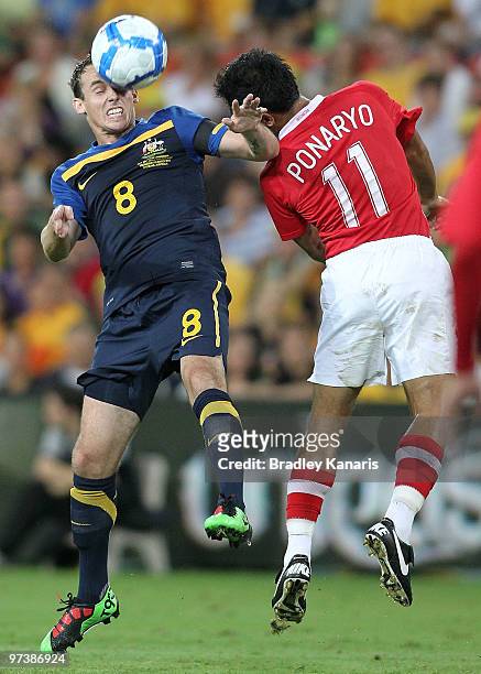 Luke Wilkshire of Australia is challenged by Ponaryo Astaman of Indonesia during the Asian Cup Group B qualifying match between the Australian...