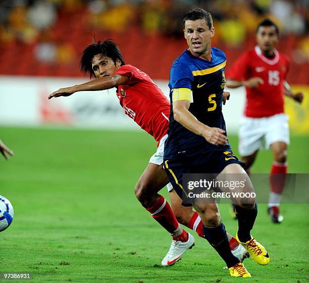 Australia's captain Jason Culina runs to the ball with Indonesia's Syamsul Bachri during their Asian Cup 2011 football qualification match in...