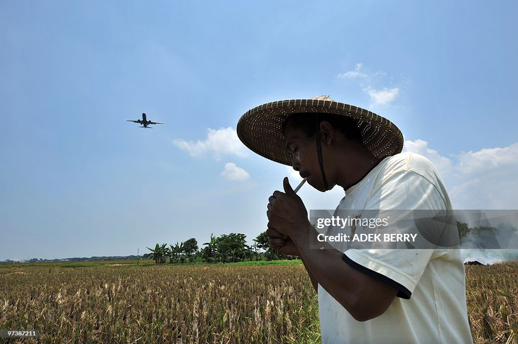 An Indonesian farmer lights up in a padd