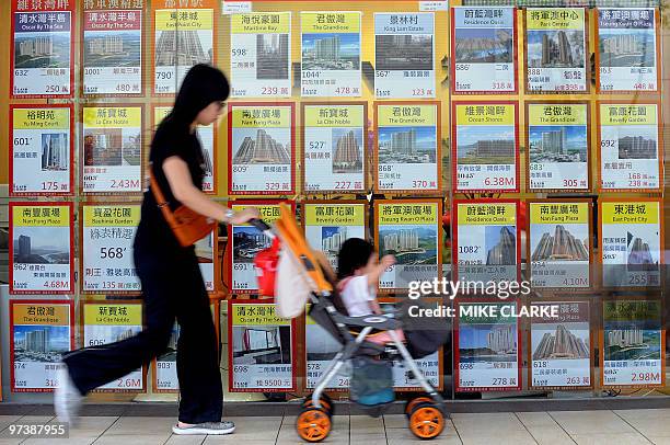 Asia-economy-property,FOCUS by Martin Abbugao A woman pushes her child past a property agent window in Hong Kong on March 3, 2010. Asian countries...