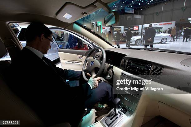 Man takes a look at a F3DM car of Chinese car manufacturer BYD during the second press day at the 80th Geneva International Motor Show on March 3,...