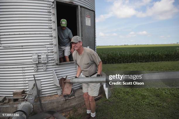 Farmer John Duffy and Roger Murphy load soybeans from a grain bin onto a truck before taking them to a grain elevator on June 13, 2018 in Dwight,...