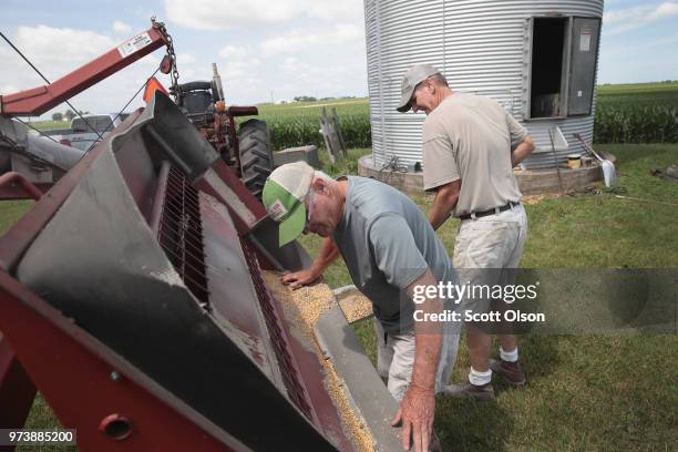 Farmer John Duffy and Roger Murphy load soybeans from a grain bin onto a truck before taking them to a grain elevator on June 13, 2018 in Dwight,...