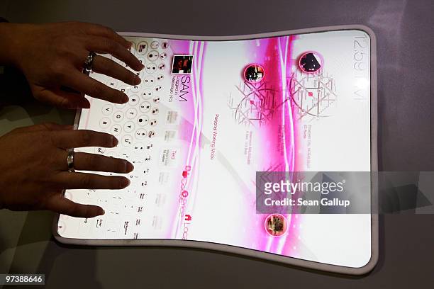 Hostess demonstrates a prototype of a touch-sensitive screen that can be rolled or folded and used as a computer or tablet at the Asus stand at the...