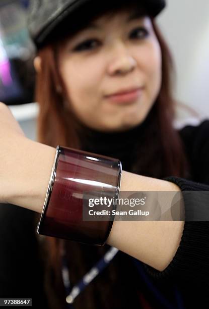 Hostess wears a prototype of a flexible bracelet that, when unrolled, can function as a mobile phone at the Asus stand at the CeBIT Technology Fair...