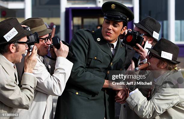 Lee Jackson, dressed as Elvis Presley, is surrounded by street theatre group Mischief La-Bas, who are dressed as press photographers as he pays a...