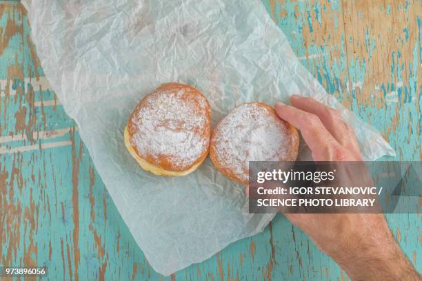 hand reaching for sugary donut - blue donut white background imagens e fotografias de stock