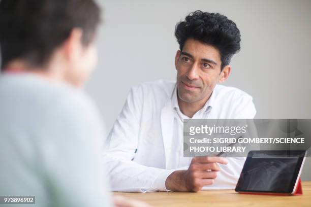 doctor discussing x-ray with patient - sigrid gombert stock pictures, royalty-free photos & images