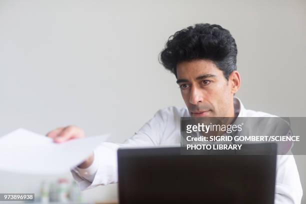doctor working on laptop - sigrid gombert fotografías e imágenes de stock
