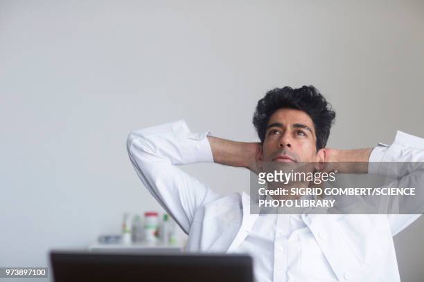 doctor thinking at his desk - sigrid gombert imagens e fotografias de stock