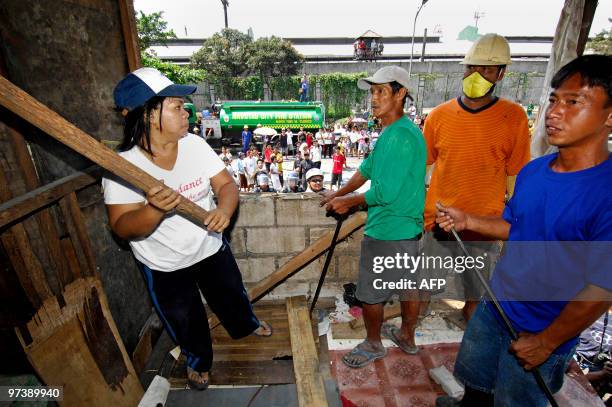 Resident threatens to strike members of a demolition team with a piece of wood during a confrontation in the Manila suburb of Navotas on March 2,...