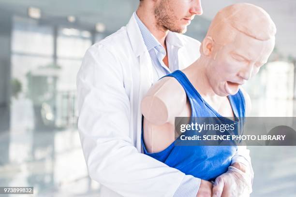 doctor practising heimlich manoeuvre - ajudar a respirar imagens e fotografias de stock