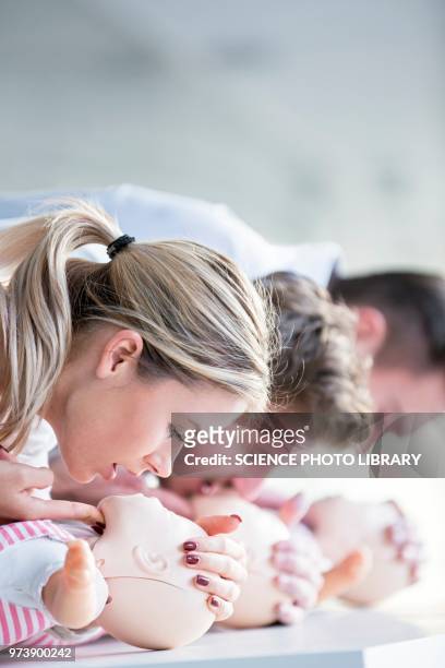 doctors practising infant cpr - erste hilfe kurs stock-fotos und bilder