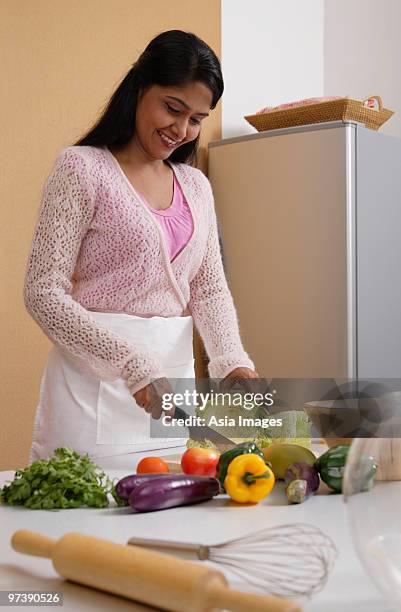 indian woman cutting vegetables in the kitchen - wife beater stock pictures, royalty-free photos & images