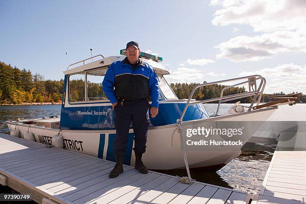 watershed security guard standing at a dock - beschützer stock-fotos und bilder
