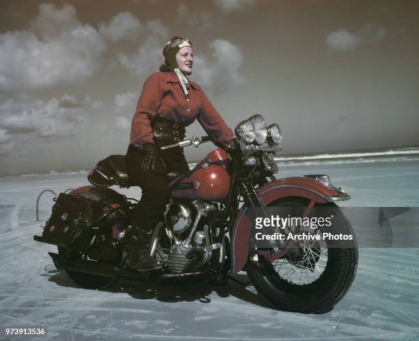 Young woman astride a 1947 Harley-Davidson FL Knucklehead motorcycle, possibly at Daytona Beach, Florida, circa 1948.