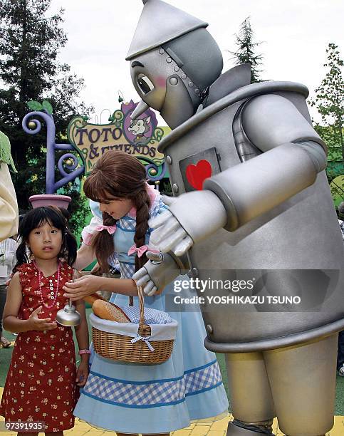 Characters of the Wizard of Oz, Dorothy and tinman greet a young guest during the new large attraction "Land of Oz" of the Hollywood theme park...