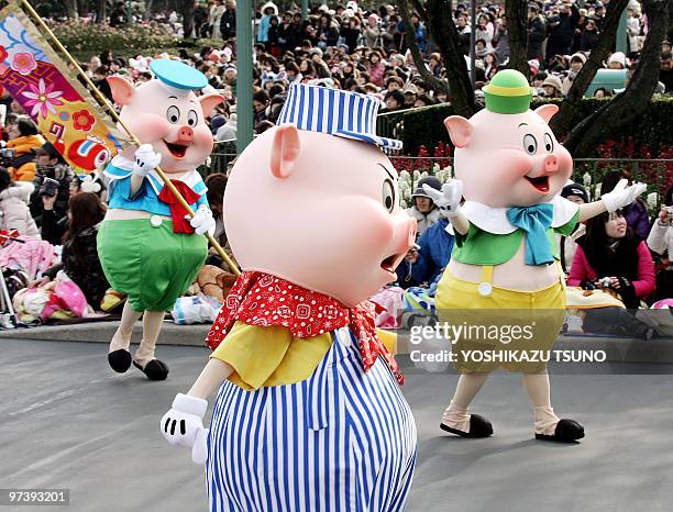 The "Three Little Pigs" march through the crowd greeting guests during a New Year's Day parade ahead of the 'Year of the Pig' at Tokyo Disneyland in...