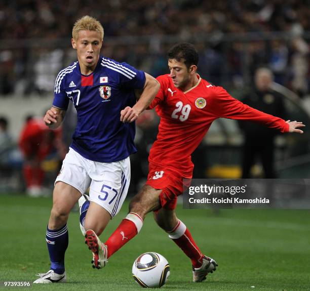Mohamed Hubail of Bahrain competes with Keisuke Honda of Japan during the AFC Asian Cup Qatar 2011 Group A qualifier football match between Japan and...