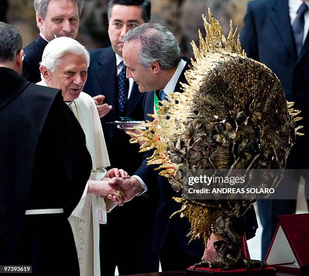 Pope Benedict XVI looks at a gift in Aula Paolo VI at the Vatican during his weekly general audience on March 3, 2010 . Pope Benedict XVI will visit...