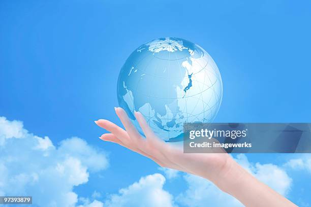woman holding globe against sky - 2000 world series stock pictures, royalty-free photos & images