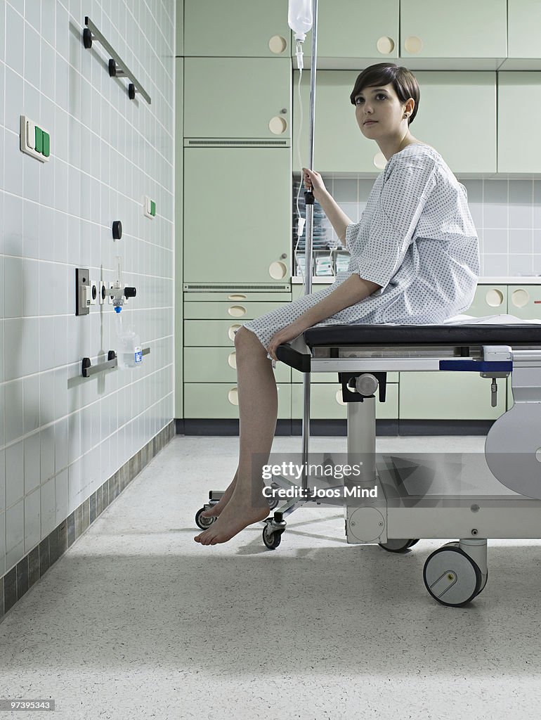 Woman waiting on examination table in hospital