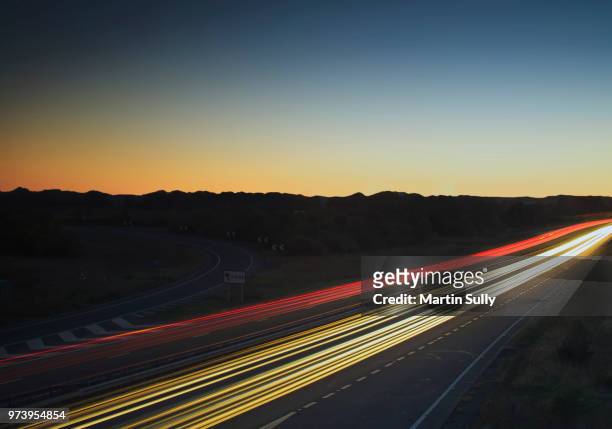 colorful light trails on highway, naseby, northamptonshire, england, uk - naseby stockfoto's en -beelden