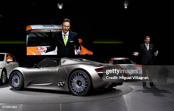Michael Macht, chief executive officer of Porsche SE, is pictured on a screen next to the Porsche 918 Spyder concept car during the first press day...