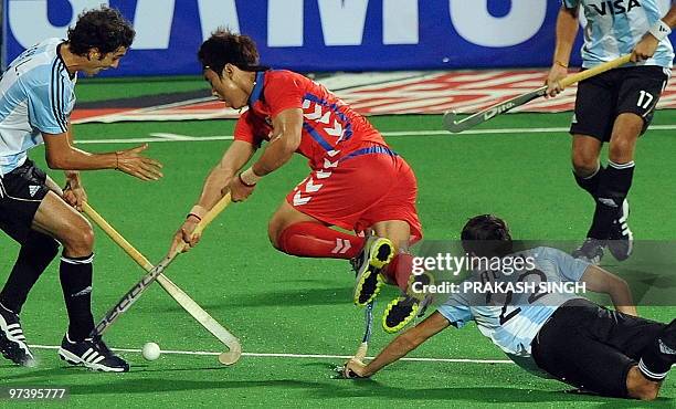 Argentinian hockey player Matias Rey tries to take the ball from South Korean Jang Jong Hyun during their World Cup 2010 match at the Major Dhyan...