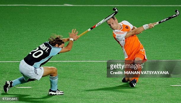 Netherlands hockey player Taeke Taekema lofts the ball as Argentinian hockey player Tomas Argento looks on during their World Cup 2010 match at the...