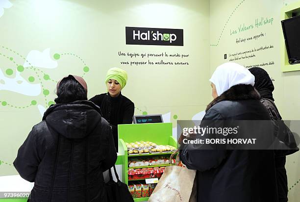 Women queue up at the cashier at "Hal' shop", a supermarket selling halal food, in Nanterre, a Paris suburb, where they bought food some hours after...