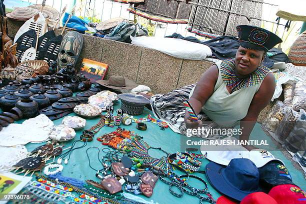 Street vendor Londiwe Khanyile wears a Zulu hat and a necklace of beads at her business on the Durban beachfront on March 1, 2010. Durban, home to...