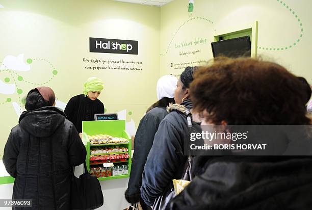 Women queue up at the cashier at "Hal' shop", a supermarket selling halal food, in Nanterre, a Paris suburb, where they bought food some hours after...