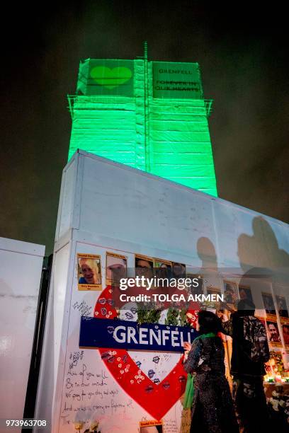 Members of the public hold a vigil and commemoration near Grenfell Tower in west London at midnight June 14, 2018 to honour the 71 people who died...