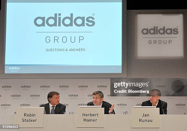 Robin J. Stalker, chief financial officer of Adidas AG, left, sits with Herbert Hainer, chief executive officer of Adidas AG, center and Jan Runau,...