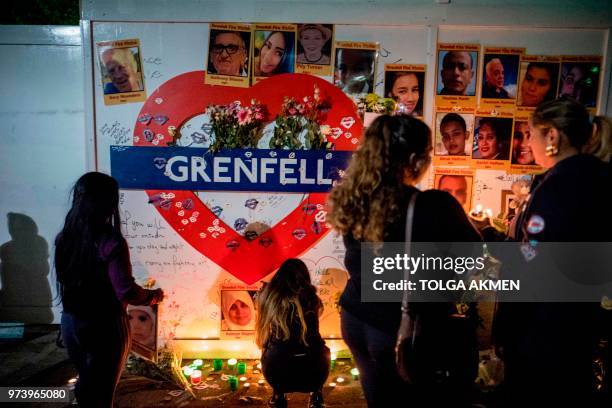 Members of the public hold a vigil and commemoration near Grenfell Tower in west London at midnight June 14, 2018 to honour the 71 people who died...